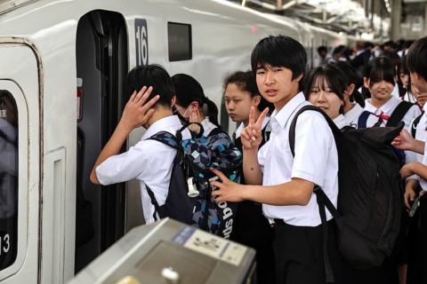 Students wearing school uniforms board a train at the train station in Kyoto, Kyoto, Japan
