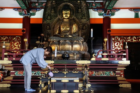 Woman cleaning a magnificent Buddha temple altar, Kyoto, Higashiyama, Japan