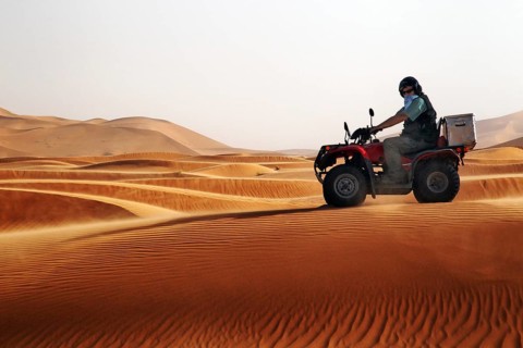 Quad driver navigates the impressive sand dunes of Erg Chebbi, Erg Chebbi, Morocco