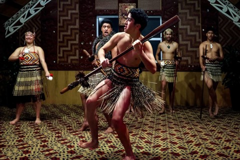 Maori warrior dancing with a spear in a tribal house, Rotorua, Te Puia, New Zealand