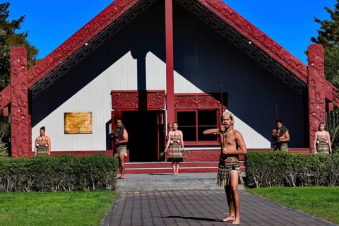 Maori group performs a welcoming ceremony in front of a traditional marae in Rotorua, Rotorua, Bay