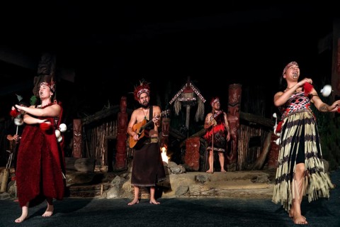 Group of Maori wearing traditional dress at a dance performance on stage in Rotorua, Rotorua, Bay
