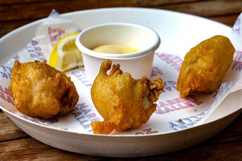Fried oysters on a plate with lemon and dip at Wynard Quarter Fish Market, Auckland, North Island,