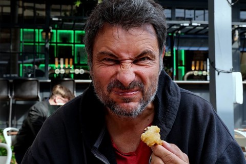 Man tries fried oysters at Wynard Quarter fish market in Auckland, Auckland, North Island, New