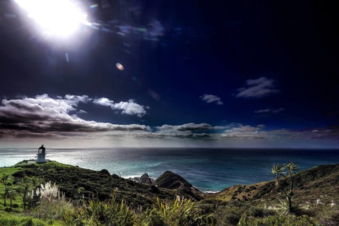 Landscape near Cape Reinga with lighthouse, bright sunlight and lush greenery, Cape Reinga,