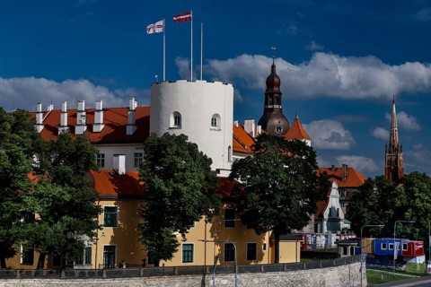 Historic castle with red roof on the Düna in Riga surrounded by trees, Riga, Vidzeme, Latvia