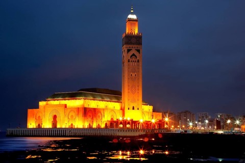 Illuminated Hassan II mosque at night, magnificent architecture on the coast of Casablanca,