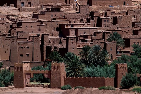 Ait Benhaddou with palm trees in front of the impressive clay architecture, Ait Benhaddou,