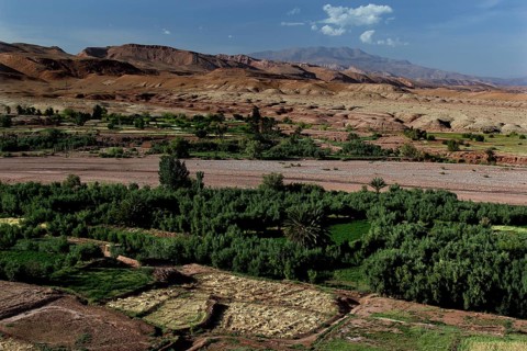 Extensive panoramic view of Ait Benhaddou with green valleys and surrounding mountains, Ait
