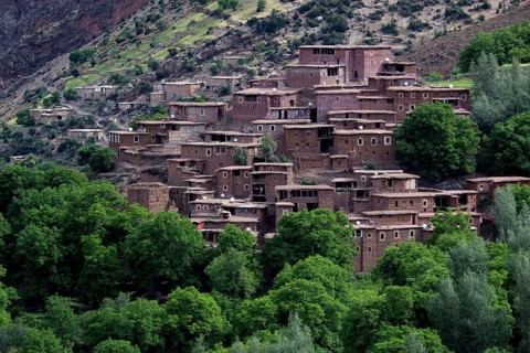 Traditional village in the High Atlas with terraced houses and green trees, zero