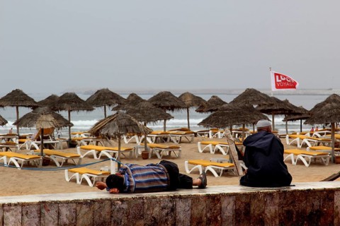 Umbrellas and sun loungers line Agadir beach, where gentle waves break, Agadir, Morocco