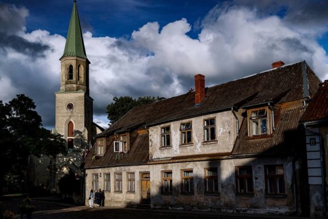 St. Catherine's Church and old houses under dramatic skies in the old town, Kuldiga, Latvia