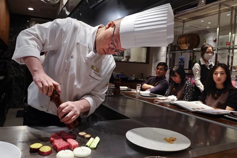 Chef prepares Kobe steak and guests watch in amazement at the Kobe Plaisir restaurant, Kobe, Hyogo,