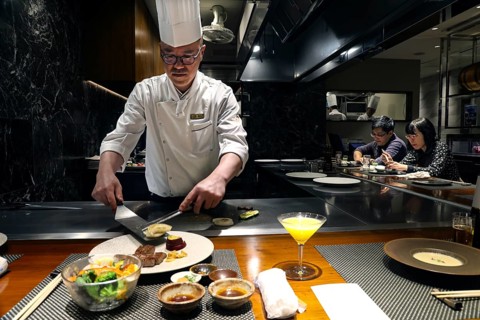 Chef prepares teppanyaki dish in front of guests at Kobe Plaisir restaurant, Kobe, Hyogo, Japan