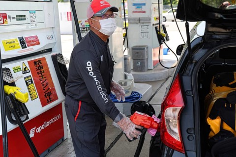 An employee at a gas station in Kyoto refuels a car, Kyoto, Kyoto, Japan