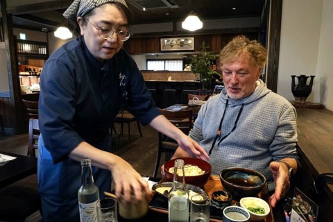 Man receives udon noodles in a traditional restaurant, Kyoto, Okazaki, Japan