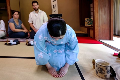 Tea master bows during tea ceremony, guests watching, Kyoto, Higashiyama, Japan
