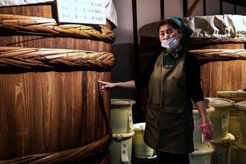 A woman explains how to make miso at the Ishii Miso Brewery in Matsumoto, Matsumoto, Japan