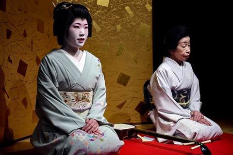 Two geishas sit next to each other in the Nishi Chaya tea house district in Kanazawa, Kanazawa,
