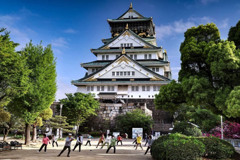 People practice tai chi in front of Osaka Castle, Osaka, Japan