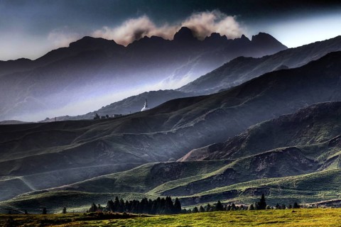 Dramatic crater landscape with clouds above mountain peaks, Aso, Kumamoto, Japan