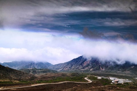 Far-reaching view of mountains and volcanic craters under dramatic cloud formation, Aso, Kumamoto,