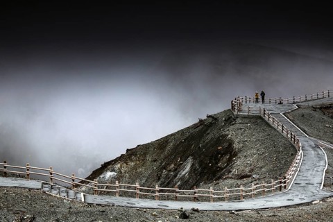 Mystical crater landscape in rain with dramatic sky, Aso, Japan