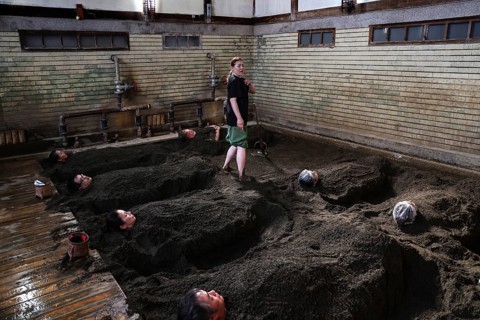 Visitors to Takegawara Onsen are deeply relaxed in sand baths, Beppu, Oita, Japan