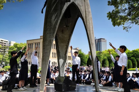 Students stand at a ceremony at the Peace Monument in Hiroshima Peace Park, Hiroshima, Japan