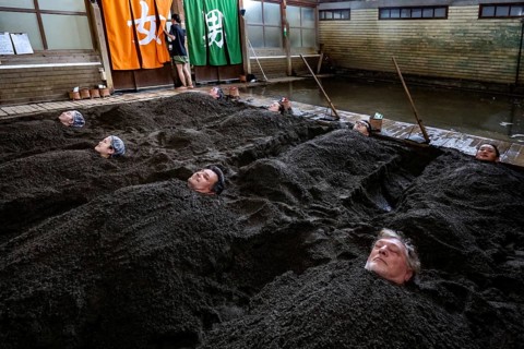 Attendees enjoy a unique sand bath at Takegawara Onsen in Beppu, Beppu, Oita, Japan