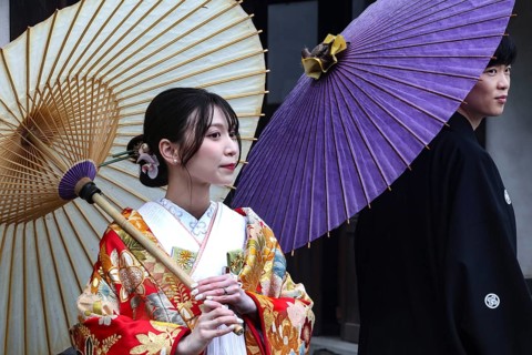 A traditionally dressed couple wearing Japanese umbrellas at a photo shoot, Himeji, Hyogo, Japan
