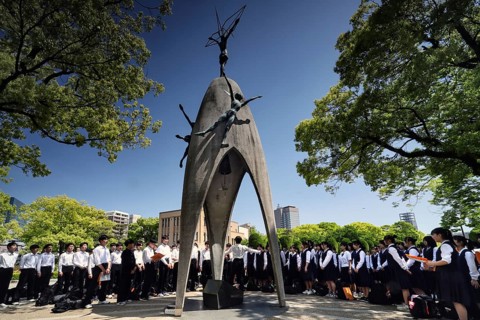 Students gather around the peace monument in Hiroshima Peace Park, Hiroshima, Japan