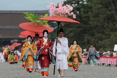 Traditional procession with geishas and red umbrellas during Aoi Matsuri in Kyoto, Kyoto, Japan