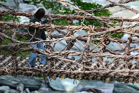 Person crossing the rustic Kazurabashi rope suspension bridge, Iya, Japan