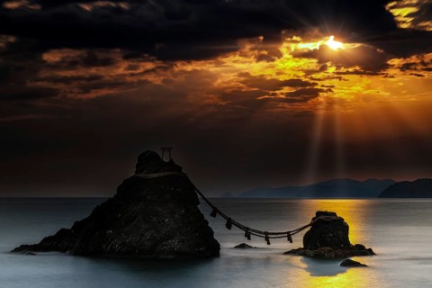 Married rocks at sunrise symbolized by a rope that connects them, Ise, Japan