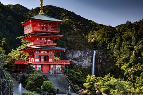 Red pagoda in front of Nachi Waterfall in the green forest of Seiganto-ji, Nachi, Wakayama, Japan
