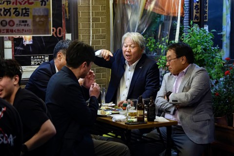 Men in suits talk vividly at a table in the Hoppy-dori, Tokyo, Tokyo, Japan