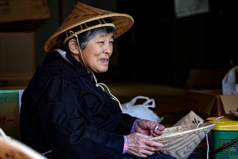 Elderly woman in Tsumago making traditional hats, Tsumago, Japan
