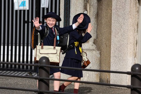 Two laughing schoolchildren in uniforms on their way to school in Osaka, Osaka, Japan