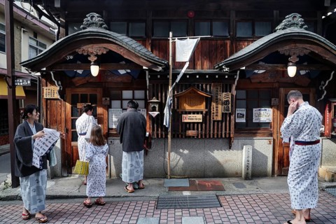 People in yukata in front of a traditional public bath, Yamanouchi, Japan