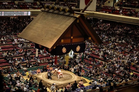 Sumo competition in the big Kokugikan with numerous spectators and traditional roof, Tokyo,