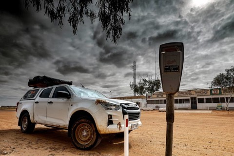 Off-road vehicle next to a parking meter under dramatic sky in William Creek, William Creek, South