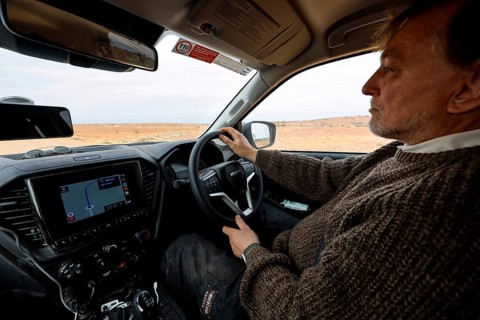 Man in a car on an off-road track in the outback with navigation system, Oodnadatta Track, null,