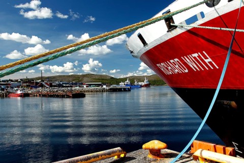 View of the bow of a Hurtigruten ship in the sunny port of Kirkenes, Kirkenes, Finnmark, Norway