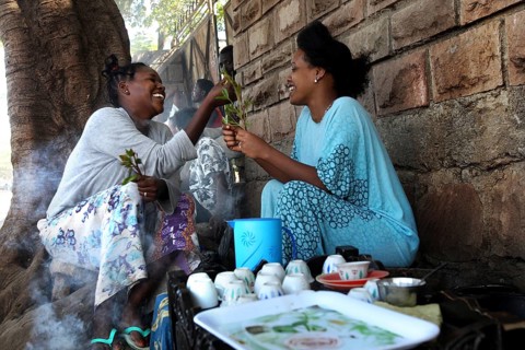 Two woman enjoy a traditional coffee ceremony and share moments of laughter, Asbe Teleri, Afar,