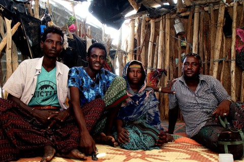 Four people sit in a simple hut in Ahmedela, Ahmedela, Tigray, Ethiopia