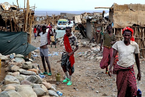 Busy street in a village with traditionally dressed residents and simple huts, Ahmedela, Afar,