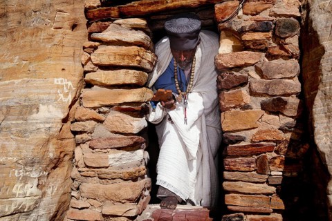 Priest in traditional dress enters the rock church Abba Daniel Krokor, null