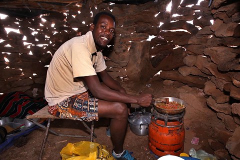 Kusay cooks using traditional methods in the Erta Ale Camp Hut, Erta Ale, Ethiopia