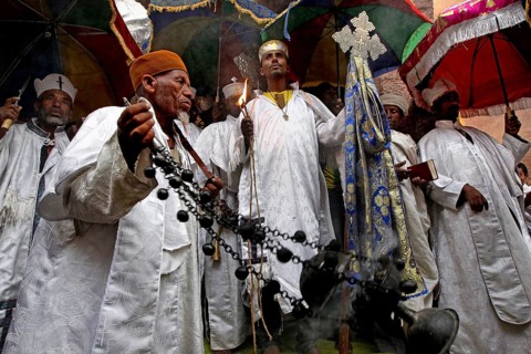 Religious procession with men wearing traditional clothing and crosses, Lalibela, Amhara, Ethiopia